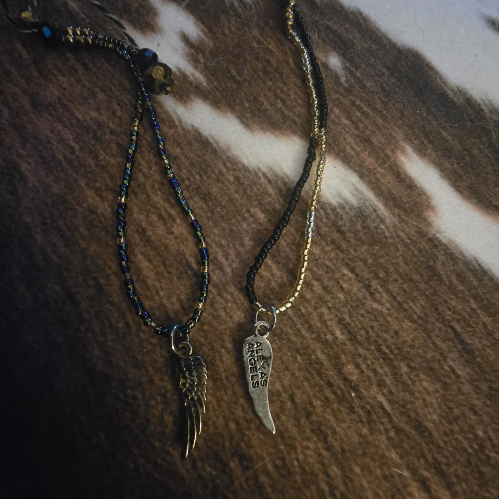 Gold Wing Charm Bracelets. One‎ With Black Accents And One With Blue.